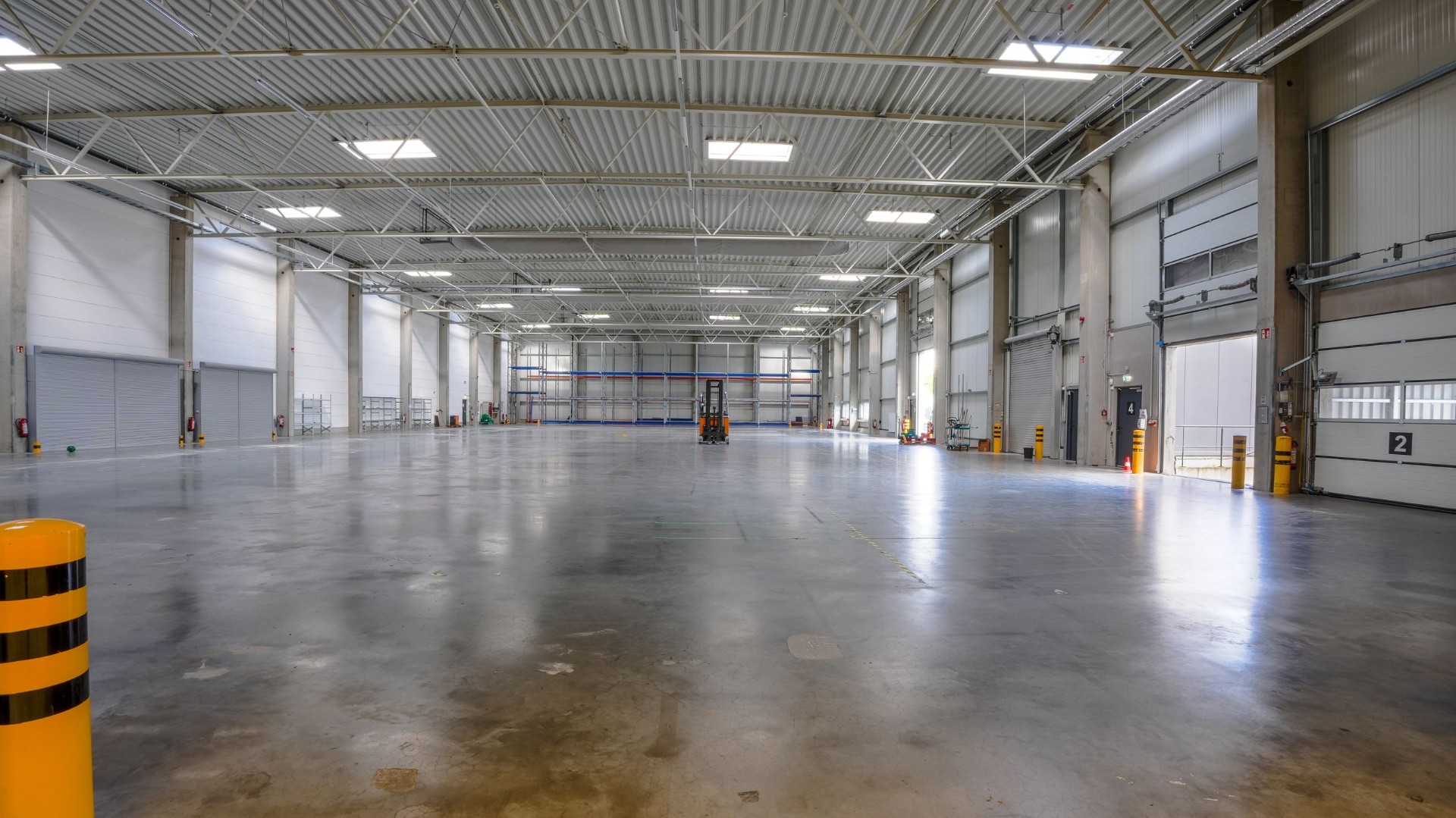 Weite Lagerhalle mit polierten Betonboden und Toren